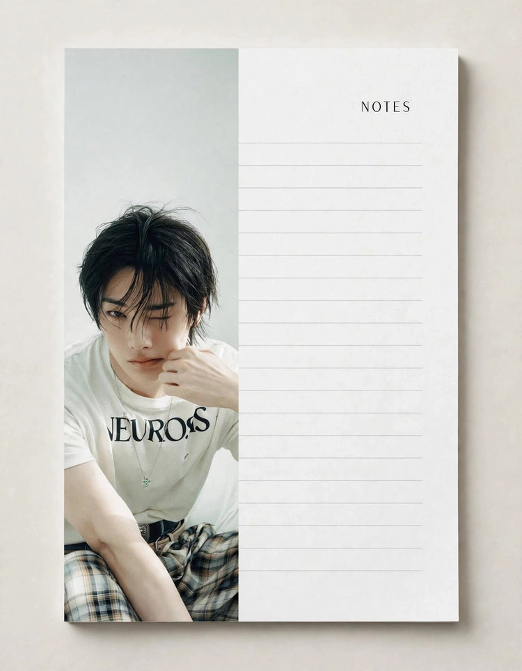 A vertical lined notes pad with a printed photo of a young man on the left half and the word NOTES on the right half, photographed against a light neutral background.
