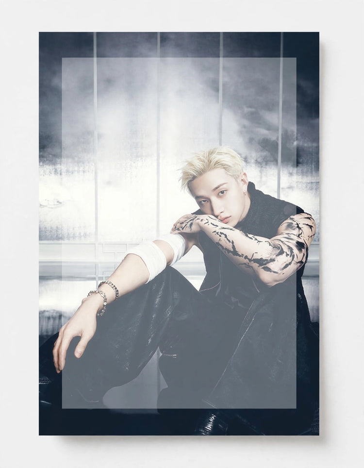 A vertical photographic print of a blonde man with tattoos sitting in a dark, smoky studio setting, wearing a black sleeveless top and black pants. The print is shown against a clean white background with a subtle drop shadow.