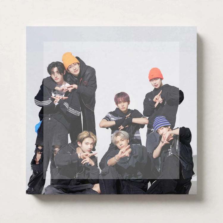 A square wall-mounted print or canvas featuring a group photo of seven young men posing together in dark streetwear, shown against a light neutral wall.