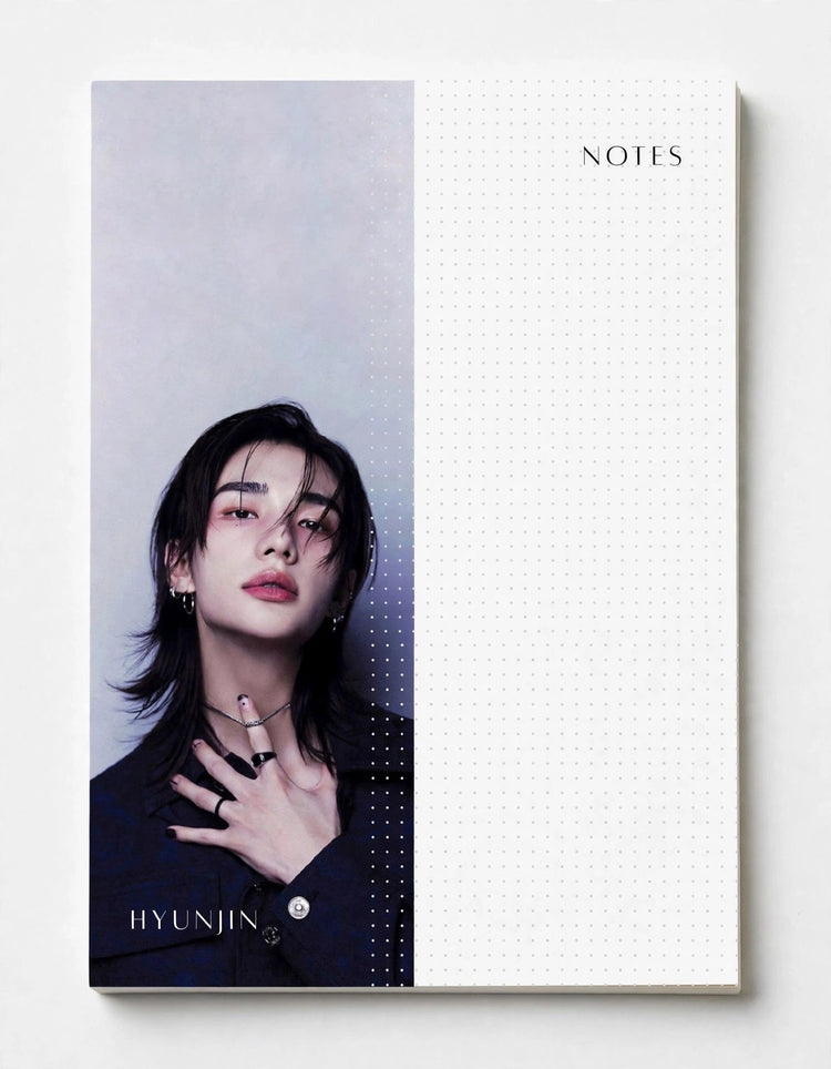 A hardcover notebook with a split design, featuring a portrait of Hyunjin from the K-pop group STRAY KIDS on the left half and a white dotted grid section labeled 'NOTES' on the right half.