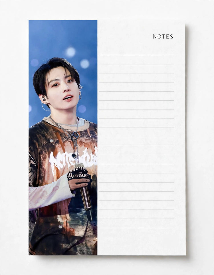 A vertical notepad with a printed photo of a male artist on the left side and lined writing space on the right, shown on a clean white background.