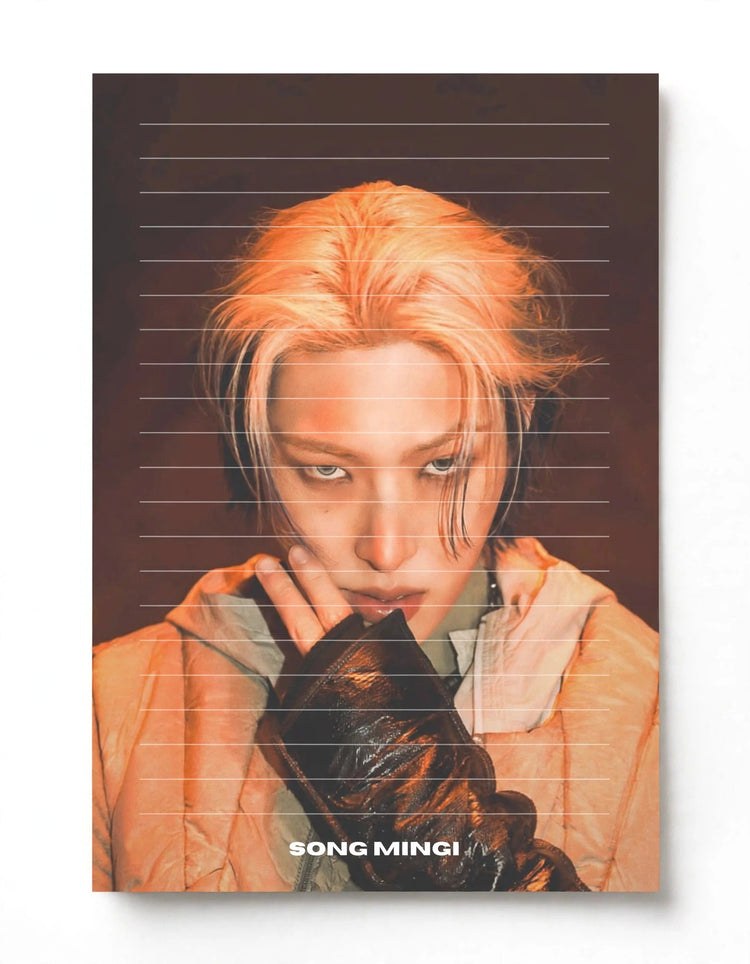 A vertical poster print featuring a stylized portrait of Song Mingi with peach-pink hair, wearing a light peach jacket and dark gloves, set against a dark brown background with horizontal line details. The text 'SONG MINGI' is printed at the bottom.