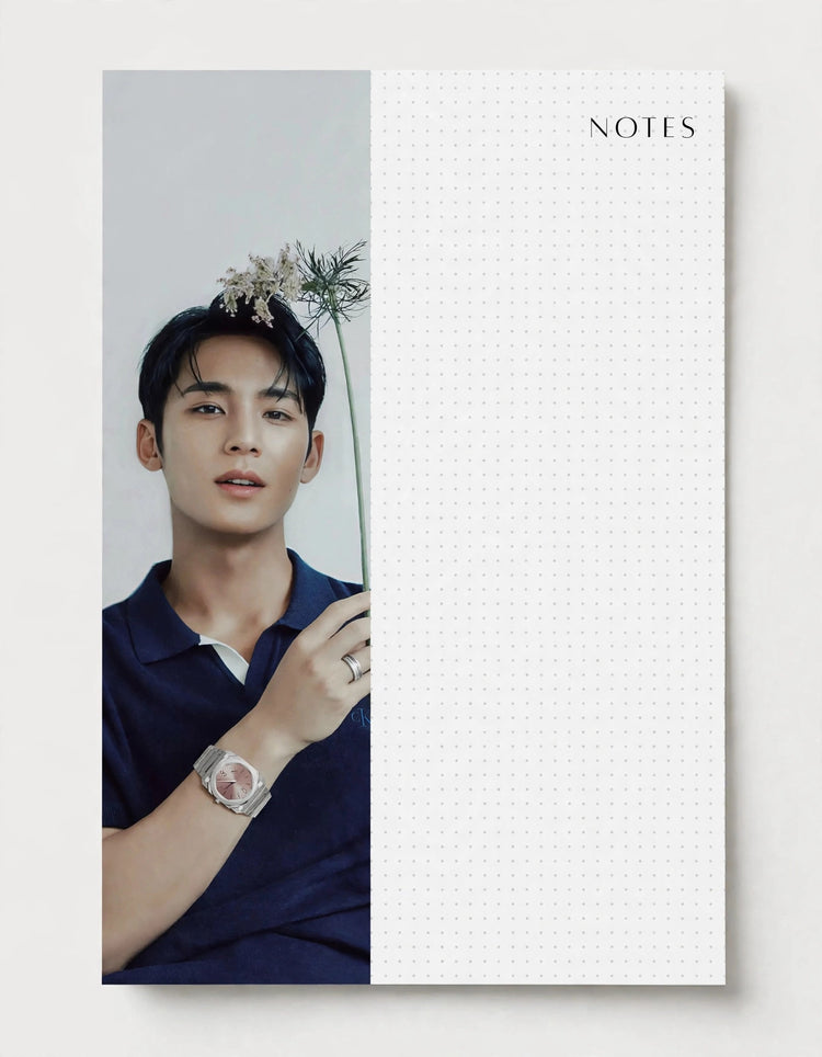 A vertical notebook or planner cover with a split design: the left half shows a portrait of a man in a navy polo shirt with flowers in his hair and a watch, and the right half is white with a faint grid and the word NOTES at the top.