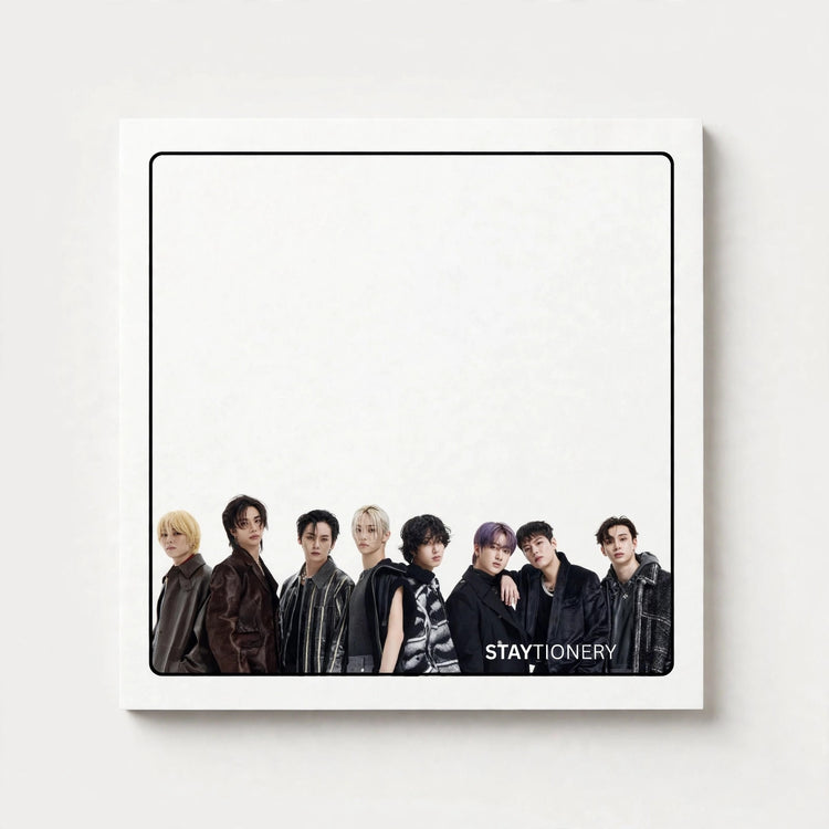 A square white art print or poster featuring a group photo of seven young men standing along the bottom, with the text 'STAYTIONERY' at the lower right. The print is shown against a light gray wall with a subtle drop shadow.
